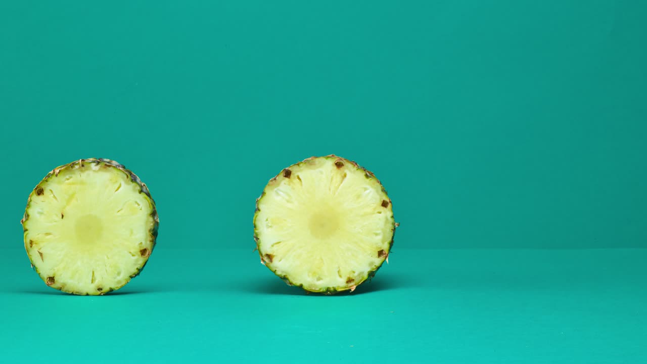 rodar la piña en rodajas en fondo de color turquesa y pasar a la placa