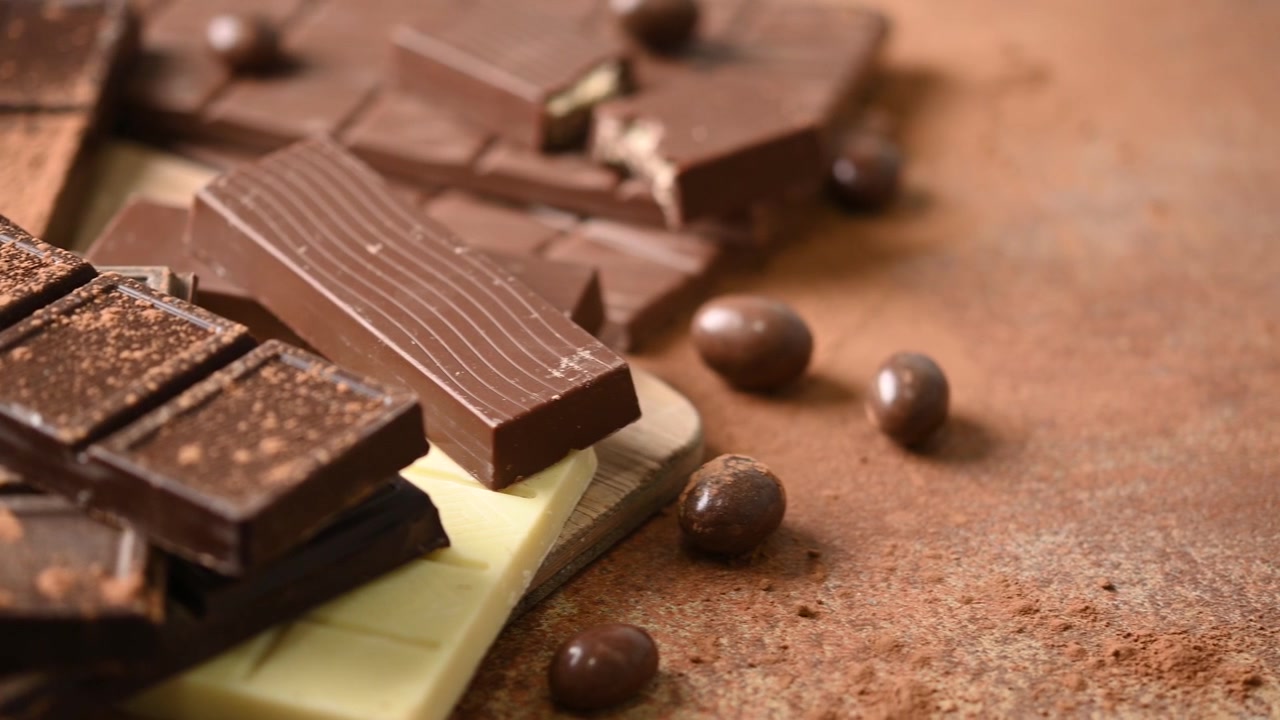 Aneka Batang Cokelat Hitam, Susu, dan Putih di atas Meja