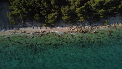 Toma-Aérea-Inclinada-Hacia-Abajo-De-Una-Playa-Cerca-Del-Bosque-En-Split,-Croacia,-Durante-El-Verano