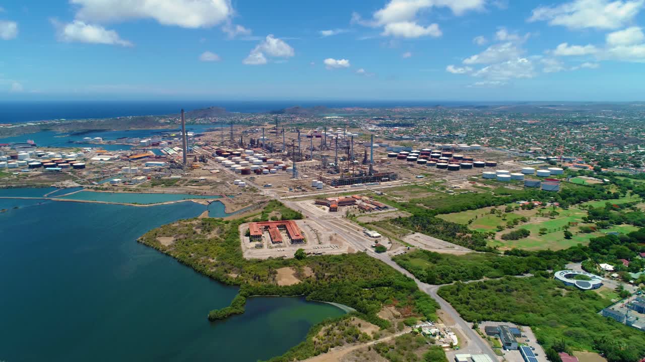 panorámica aérea de la zona industrial de la refinería de petróleo junto al campo de golf de lujo, caribe