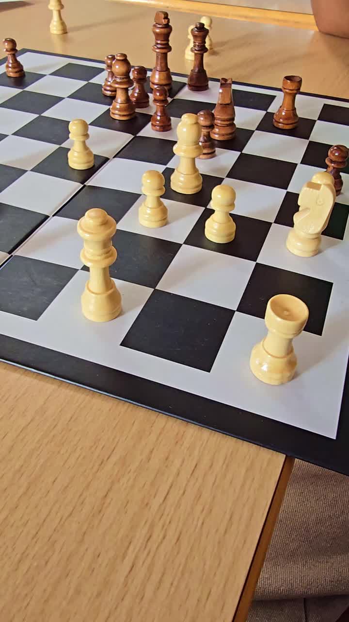 Close-up shot of an active chess game as hands move pieces across the board
