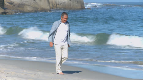 elderly man walking along the beach
