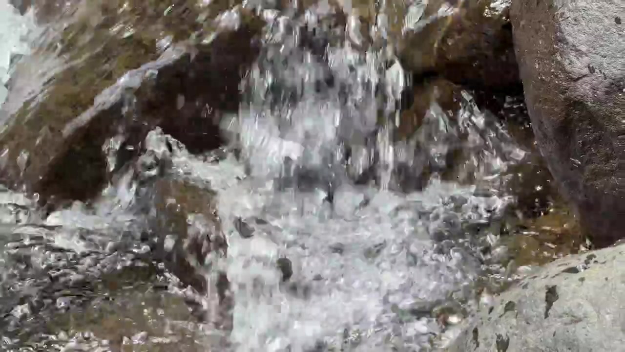 Acqua limpida che scorre sulle rocce in un ruscello di montagna