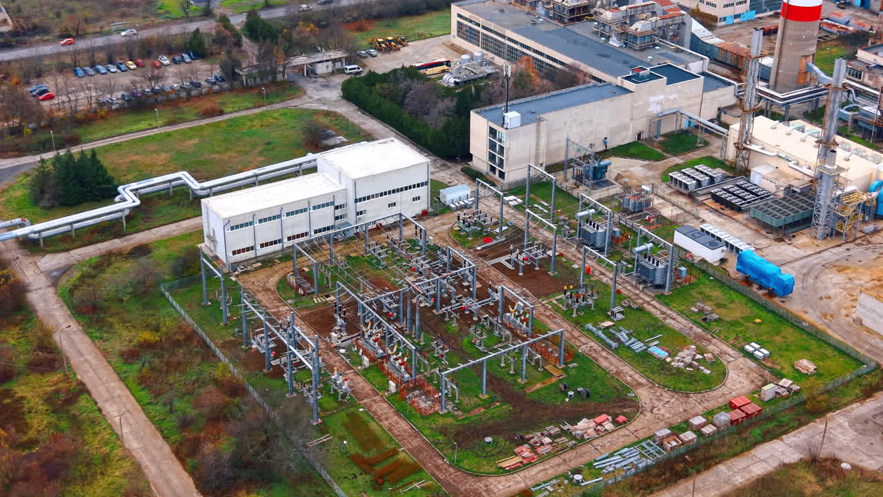 Power station located in industrial area. Aerial view of a power station showing equipment, buildings, and green spaces in an industrial setting during daytime