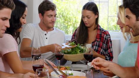 amigos felices comiendo un almuerzo saludable con vino