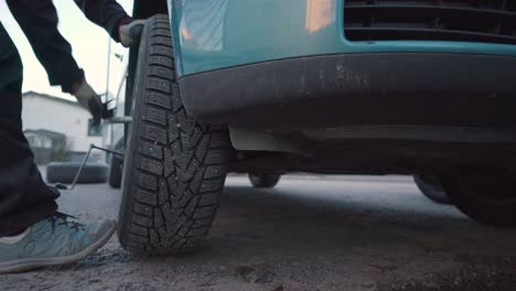 man taking off a tyre from a car