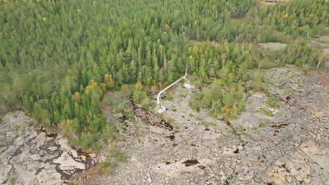 boardwalk through dense forest towards the rocky shore in sweden