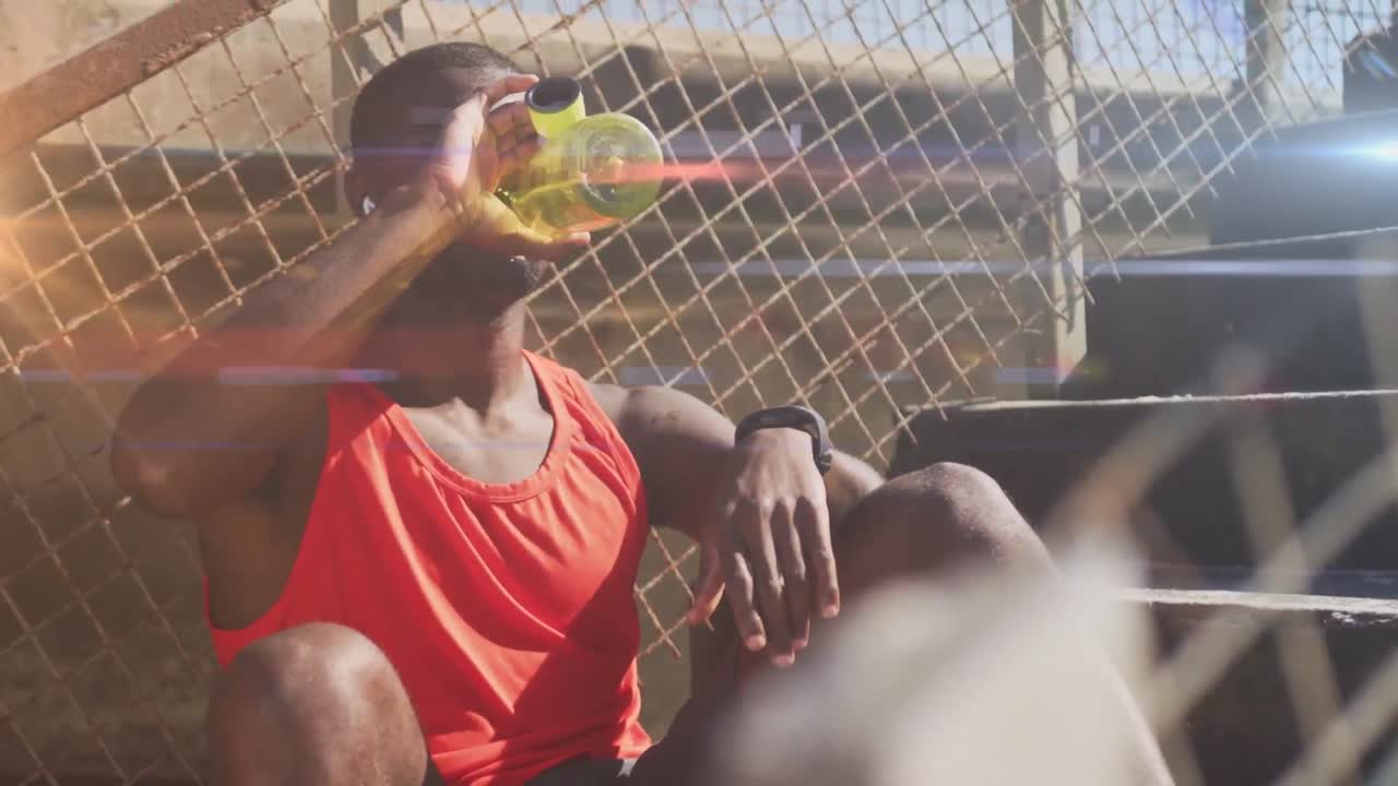 Animação de luzes brilhantes sobre um homem afro-americano se exercitando e bebendo água