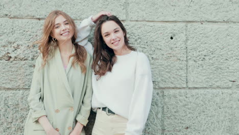 two young women smiling and posing outdoors