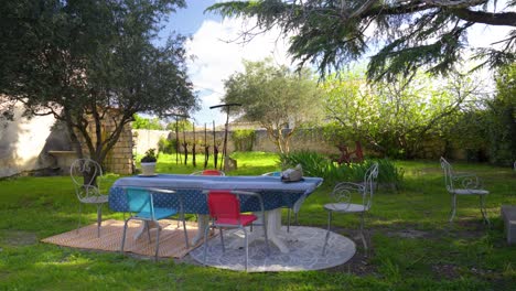 slow establishing shot of a villa garden with furniture set out in pignan