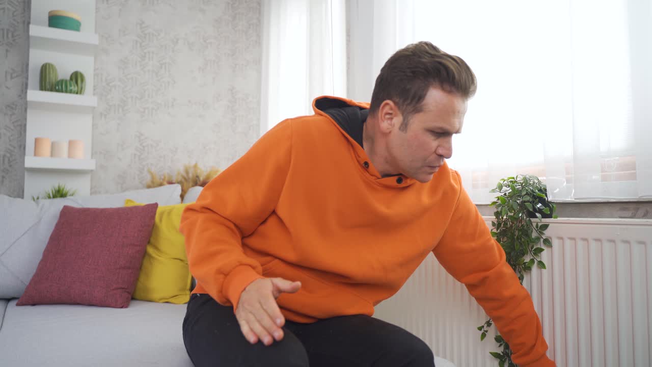 Video about a man who gets very cold at home in thick clothes.