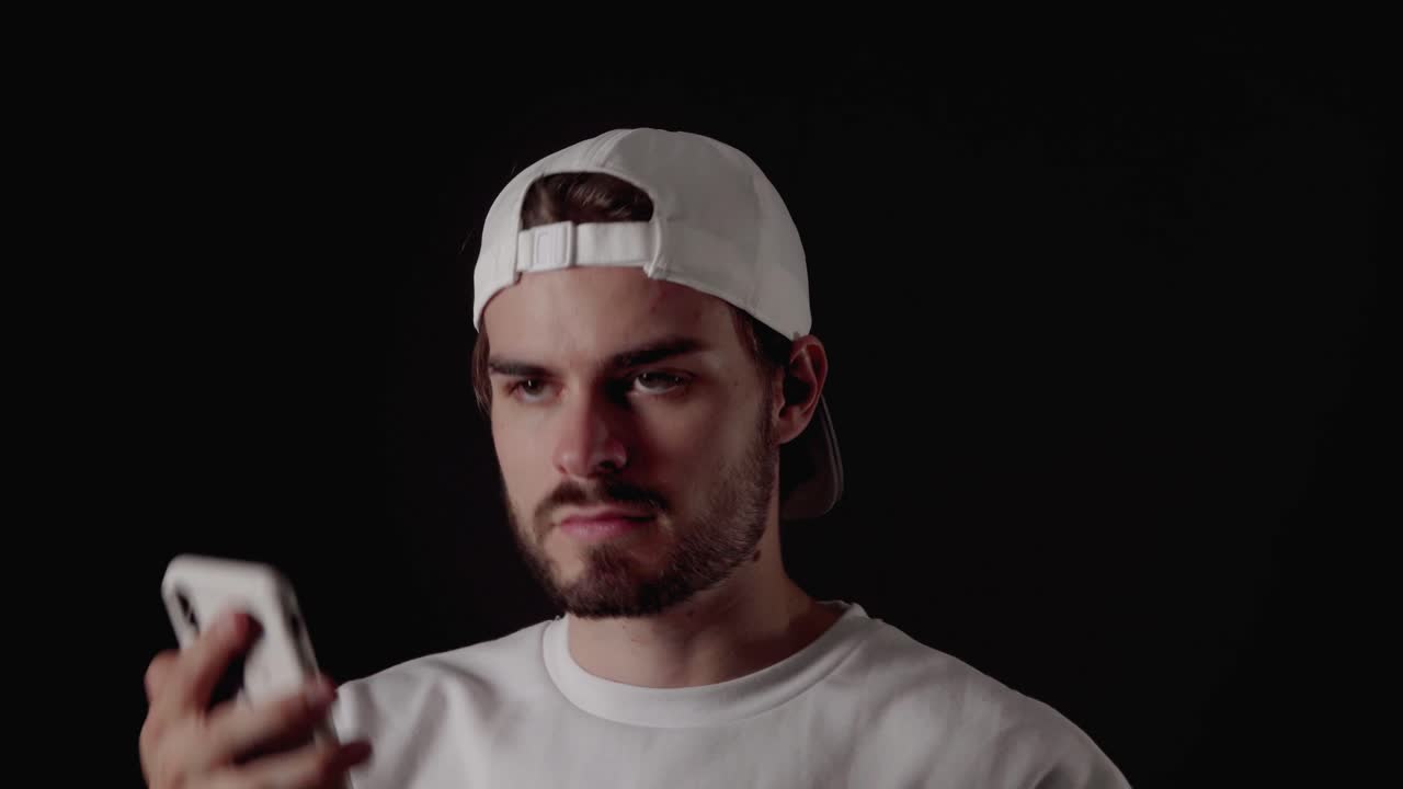 hombre de moda de los años 20 buscando y contestando el teléfono, cerca, fondo negro