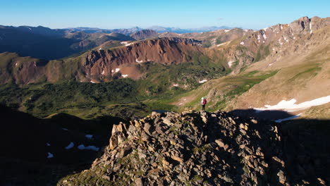 hiker on mountain peak with scenic landscape