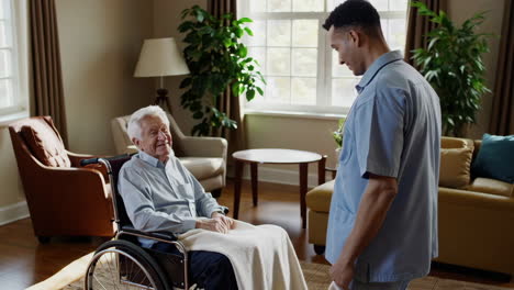 caregiver assisting an elderly man in a wheelchair at home