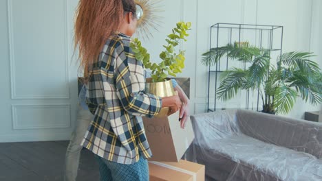 una pareja transforma la sala de estar con plantas y muebles en un apartamento acogedor