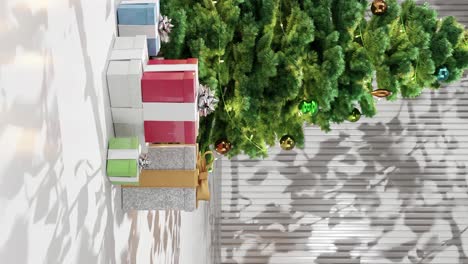 christmas tree with ornaments and wrapped presents on a white floor against a white background