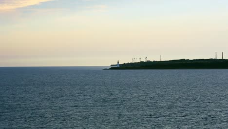faro costero con molinos de viento cerca de sydney, nueva escocia frente a la isla de cape breton