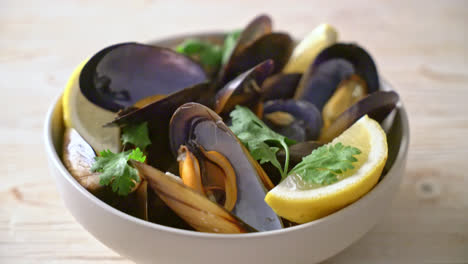 mejillones frescos con hierbas en un bol con limón