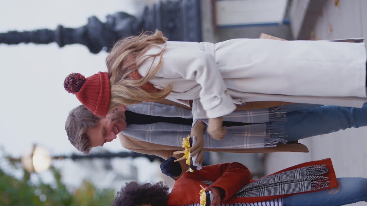 video vertical de amigos al aire libre con abrigos y bufandas comiendo papas fritas para llevar en un viaje de otoño o invierno a londres - filmado en cámara lenta