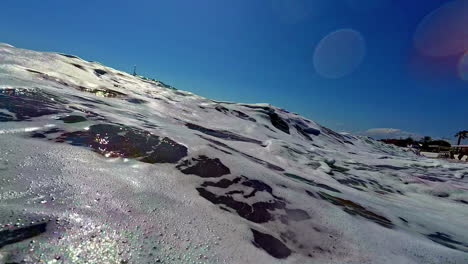 POV-Aufnahme-Beim-Surfen-Auf-Einem-Brett-Und-Den-Wellen-Am-Strand-An-Einem-Sonnigen-Tag