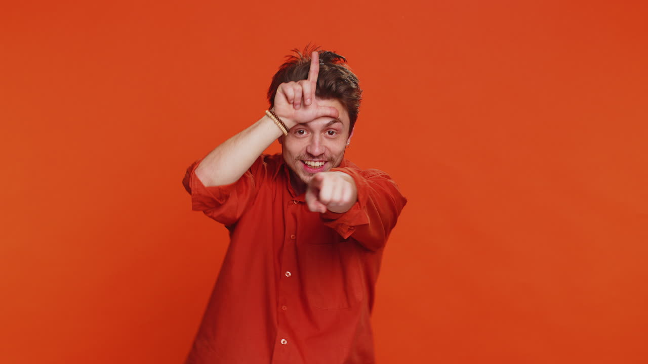 Man showing loser gesture and pointing on you blaming accusing for unsuccess expressing disrespect