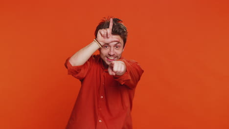 Man showing loser gesture and pointing on you blaming accusing for unsuccess expressing disrespect