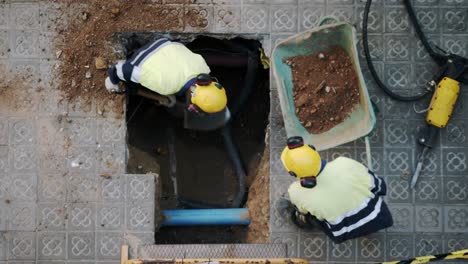 top view close-up of constructor workers digging shoveling and breaking a concrete on a street in barcelona