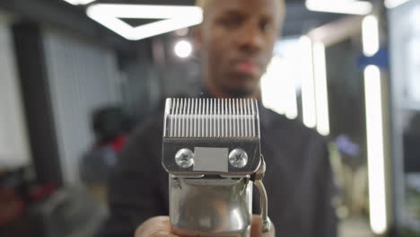 barbero negro con un cortador de cabello eléctrico