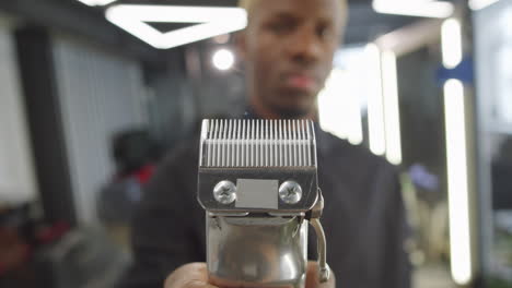 black barber holding electric hair trimmer