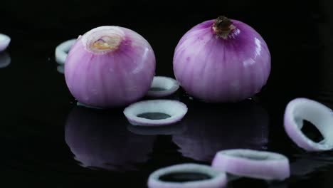 sliced red raw onion rings and onions isolated on black background