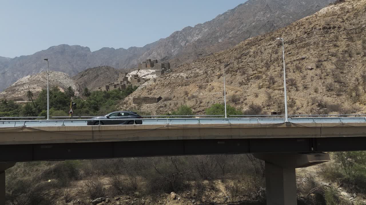 Car driving on a bridge near a mountain village