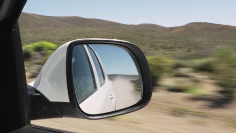 Car-driving-along-fields-in-countryside