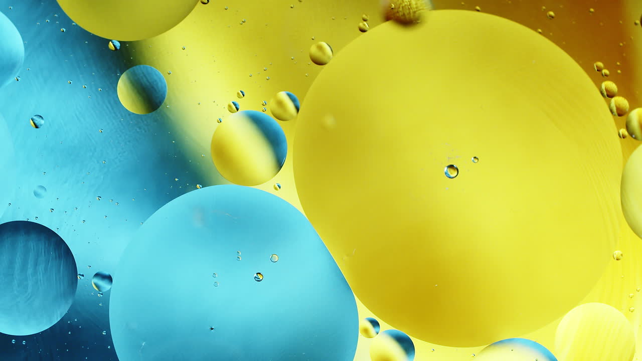Real close up oil bubbles in water rotation with color gradient abstract mixing background