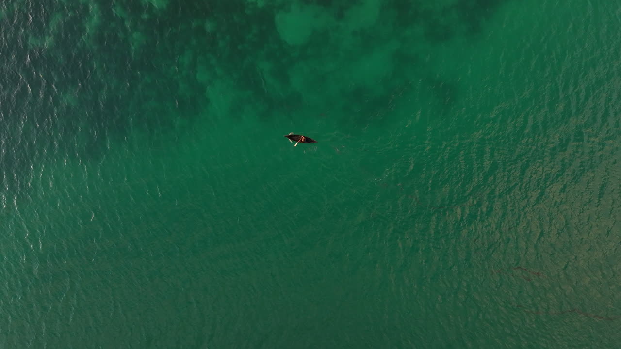 Aerial view showing person paddling in traditional canoe in the Solomon Islands