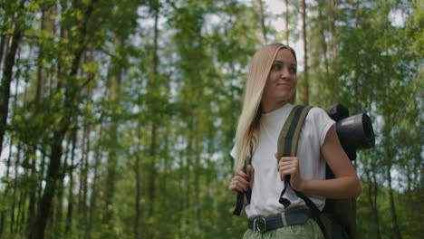 slow motion : portrait adult woman wearing shorts and t-shirt hikes through woods. young lady hiking