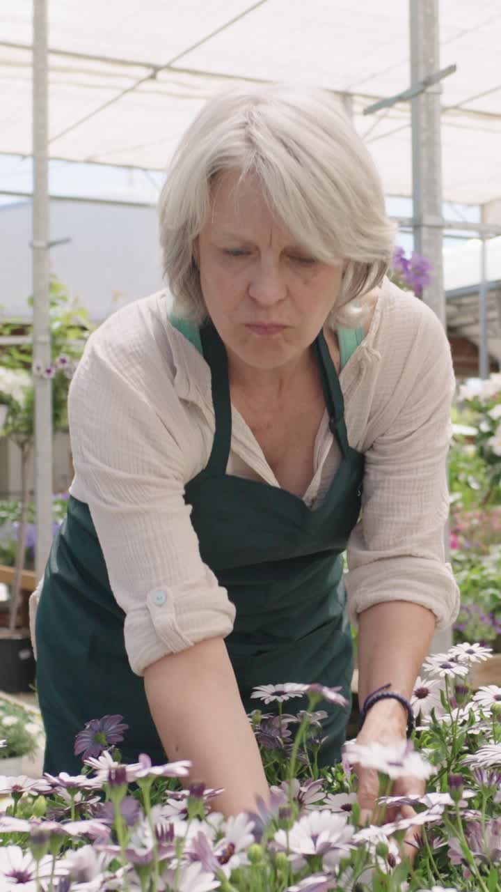Woman working with flowers in a greenhouse