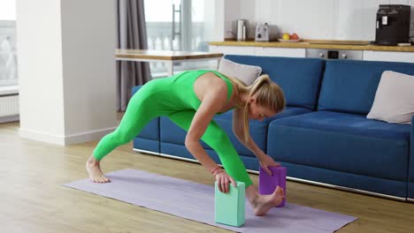 Mujer-Practicando-Yoga-Con-Bloque-De-Yoga-En-El-Salón-De-Casa