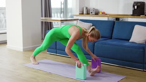 mujer practicando yoga con bloque de yoga en la sala de estar en casa