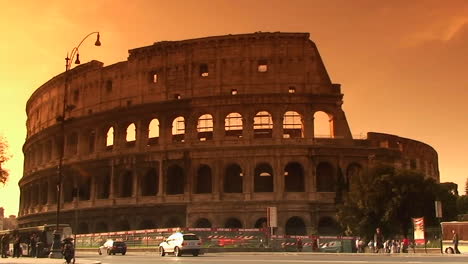 the coliseum in rome with traffic passing 2