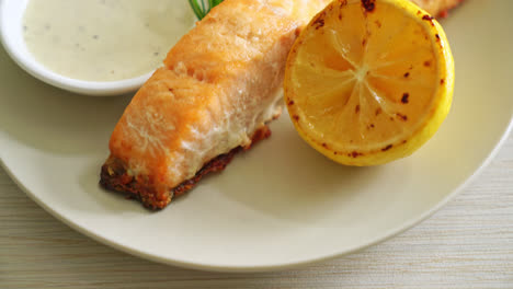 fried salmon fish and chips with lemon on plate