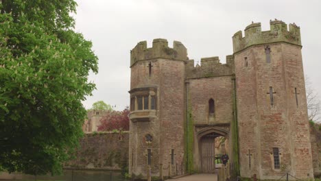 a stone castle gatehouse with a moat and bridge.