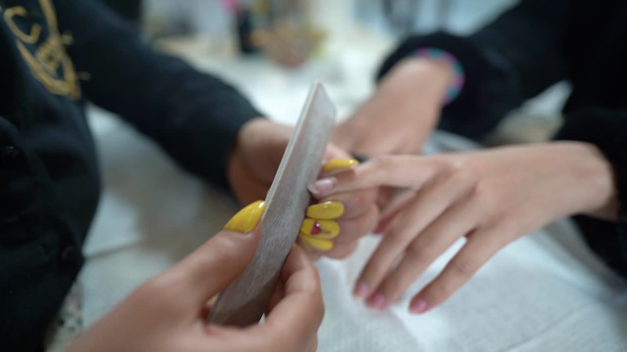 manicurista crea la forma correcta de las uñas con una lima de uñas