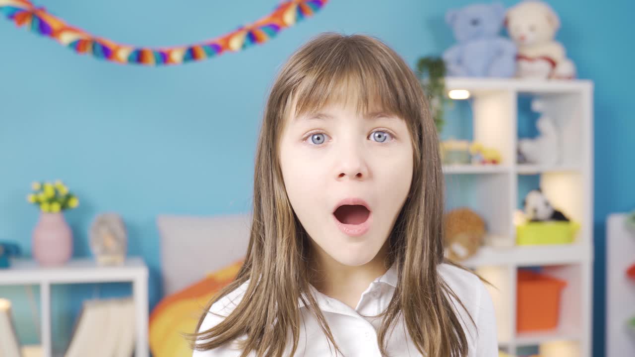 공감하는 작은 소녀는 카메라를 쳐다보고  ⁇  놀랐습니다.