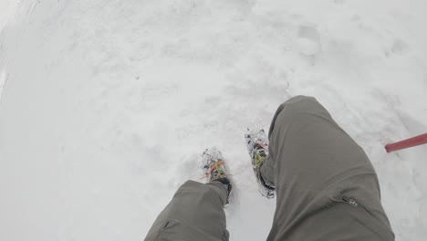 walking downhill in crampons and ice axe in hand - hiking snowy trails in tatra mountains