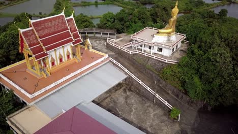 aerial shot of a statue of buddha and a temple, thailand