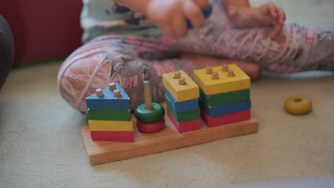 children's wooden toy. the child collects a sorter. educational logic toys for kid's. children's hands close-up.