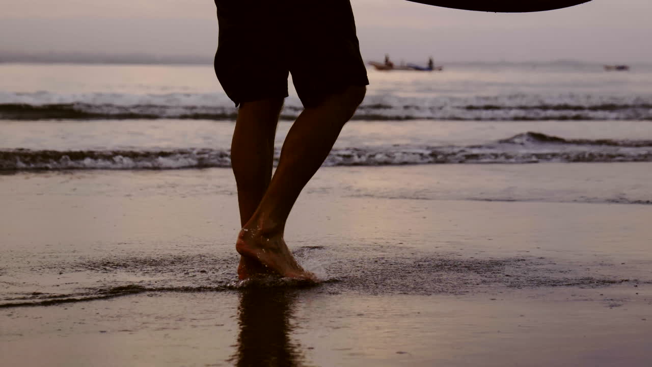 Hombre caminando por la playa al atardecer