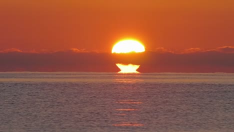 big sun on ocean horizon and calm sea