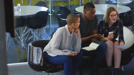 Young-mixed-race-business-team-discussing-over-documents-in-modern-office-4k