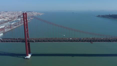 aerial drone shot spanning over the 25th of april bridge - tagus river in lisbon, portugal